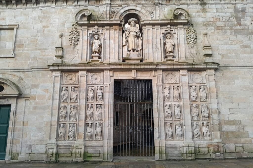Porte sainte de la cathédrale de Saint-Jacques-de-Compostelle, encadrée de statues d'apôtres et de prophètes sculptées, sur la place de la Quintana