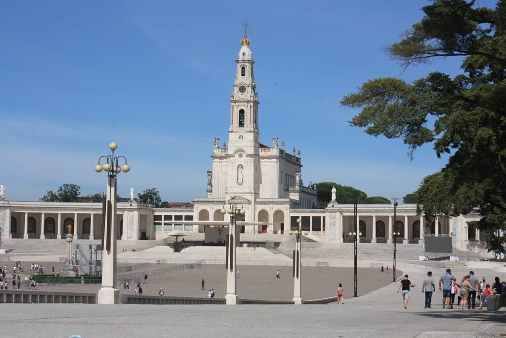 Basilique Notre-Dame-du-Rosaire de Fátima, sa haute tour blanche et l'esplanade du sanctuaire sous un ciel bleu